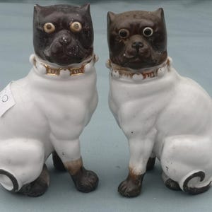 Ein Paar der späten 19th Century Continental Bisque Modelle von sitzenden Mops-Hunden um 1900