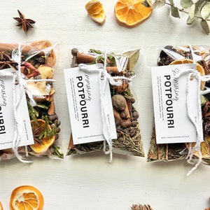 May include: Three small clear bags filled with dried orange slices, cinnamon sticks, star anise, and other spices. Each bag has a white tag that reads "Simmering Potpourri".