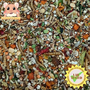 May include: A close-up image of a variety of small seeds, grains, and dried fruits, including red chili peppers, sunflower seeds, and dried orange peels. The mixture is labeled "Nutritional Values Confirmed Lab Tested Certified by ISO and UKAS Independent Laboratory".