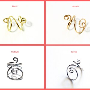 May include: Four wire rings in different metal finishes: brass, bronze, titanium, and silver. Each ring is a simple, double-loop design.