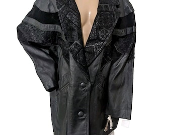 May include: A black leather jacket with a suede collar and embroidered detailing. The jacket has a button closure and two pockets.