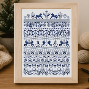 May include: Framed cross-stitch artwork with a navy blue pattern on a white background. The design incorporates floral and horse motifs. The wooden frame complements the artwork, ideal for home decoration. The frame measures approximately 30 cm x 40 cm.