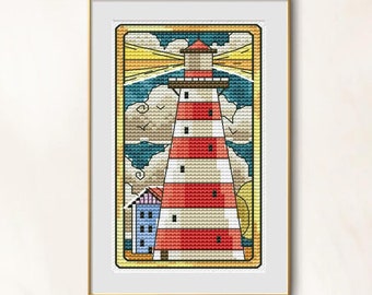 Puede incluir: Imagen de punto de cruz de un faro con rayas rojas y blancas, una parte superior marrón y un pequeño edificio azul. El fondo presenta un cielo azul con nubes y rayos de luz amarillos. La obra está enmarcada.