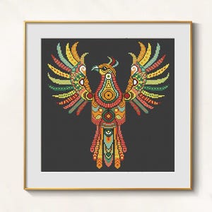 May include: A framed cross-stitch of a colorful phoenix with outstretched wings. The bird features a detailed design with red, orange, yellow, green, and blue hues against a dark background. The artwork is displayed in a gold frame.