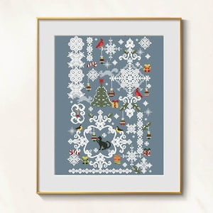 May include: Framed cross-stitch art with a winter holiday theme. The design includes snowflakes, a Christmas tree, cardinals, gifts, and a black cat. The artwork is framed in a gold-coloured frame.