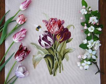 May include: An embroidered floral design featuring a bouquet of tulips in shades of red, purple, and white, with green leaves. A small bee is embroidered near the flowers. Several individual tulips in various colors are arranged to the left. A branch of white flowers is on the right.