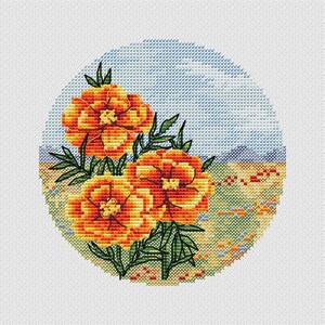 May include: A cross-stitch design depicting three orange and yellow marigold flowers with green foliage. The flowers are set against a backdrop of a blue sky and a field of wildflowers, all within a circular frame.