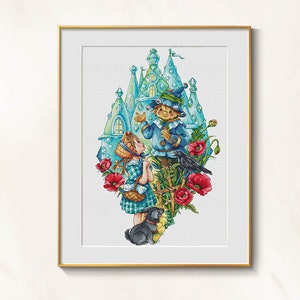 May include: A framed cross-stitch artwork featuring a whimsical scene with a girl in a checkered dress, a scarecrow, a black dog, and a crow. The artwork is set against a backdrop of a turquoise castle and red poppies.