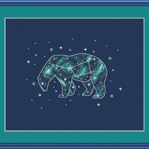 Può includere: Ricamo a punto croce di una costellazione dell'orso, con un contorno bianco e un design a nebulosa nei toni del blu e del verde. L'opera è ambientata su uno sfondo blu scuro, incorniciata in verde acqua e blu.