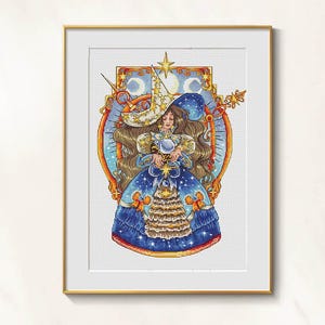 Puede incluir: Arte de punto de cruz enmarcado que representa a una bruja celestial. La bruja lleva un vestido azul adornado con estrellas y sostiene una bola de cristal. Su sombrero es blanco con estrellas doradas. La obra de arte está ambientada sobre un fondo de luna creciente y estrellas.