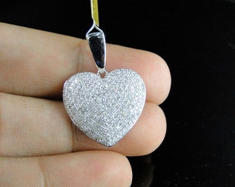May include: A silver heart-shaped pendant covered in small, sparkling diamonds.