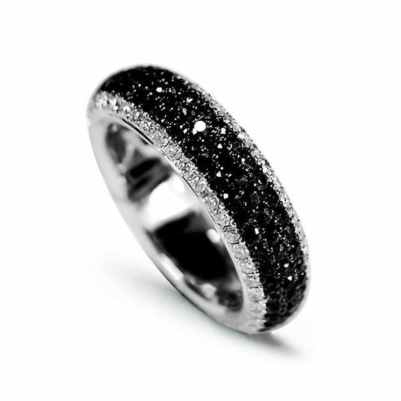 May include: A silver band ring with a row of white diamonds and two rows of black diamonds.