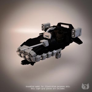 May include: A black and light grey model vehicle featuring a forward-mounted cannon, side-mounted missile launchers, and a series of rectangular armour plates along the lower front hull. The model includes a cockpit area and a rear handle structure.