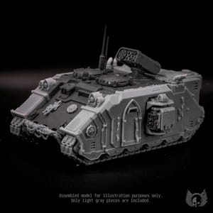 May include: A light gray plastic model tank featuring a tracked chassis, a top-mounted missile launcher, two circular hatches, and a front-mounted chain detail. The vehicle includes side doors, antenna, and various mechanical panel textures.