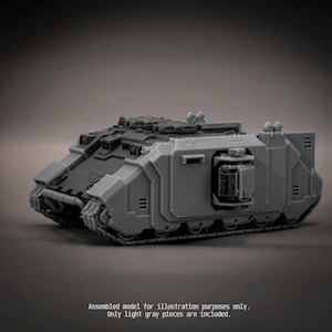 May include: A light grey plastic model tank featuring a tracked base, a rectangular chassis with side-mounted weapon ports, and a top hatch. The text at the bottom reads: Assembled model for illustration purposes only. Only light grey pieces are included.