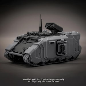 May include: A light grey plastic model tank featuring a dark grey top section, two vertical antennas, and a mounted missile launcher. The text on the bottom reads: Assembled model for illustration purposes only. Only light grey pieces are included.