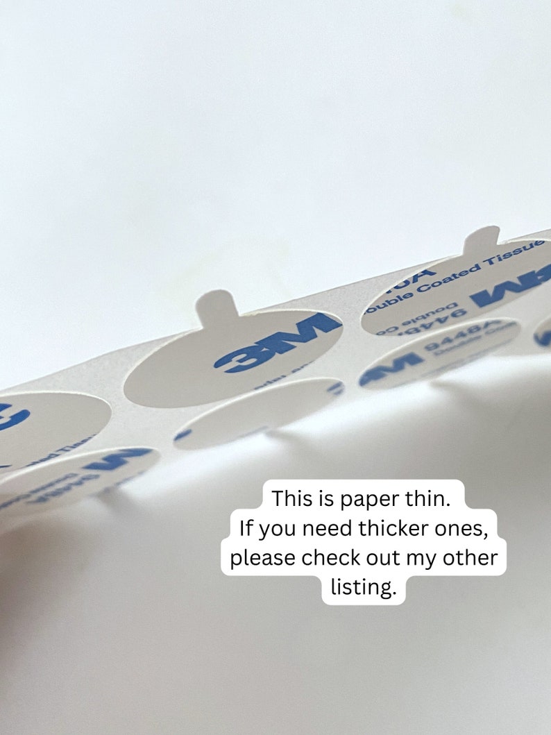 May include: A sheet of 3M double-coated tissue adhesive circles. The circles are white and have a blue 3M logo. The text "Double Coated Tissue" and "9448A" are printed on the sheet. This is paper thin. If you need thicker ones, please check out my other listing.
