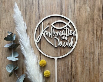 May include: A wooden circle with the words "Confirmation von David" and a fish symbol inside. The circle is attached to a wooden stick.