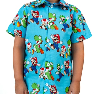 May include: A blue short-sleeved button-down shirt with a repeating pattern of Mario, Luigi, Yoshi, and Toad characters from the Super Mario Bros. video game.