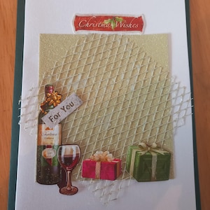 Könnte beinhalten: Handgemachte Weihnachtskarte mit grünem Rand und weißem Innenraum. Die Karte zeigt eine Weinflasche, ein Glas Rotwein und zwei verpackte Geschenke. Die Worte "Christmas Wishes" und "For You" sind ebenfalls sichtbar.