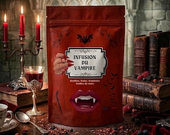 Puede incluir: Una bolsa de té roja oscura con el texto Infusion du Vampire, que presenta un gráfico de una mano con uñas largas rojas, labios de vampiro con colmillos, un murciélago y el texto Rooibos, fraise, framboise, feuilles de mûre en el frente.