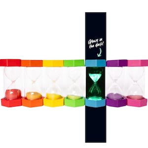 May include: A collection of colorful hourglasses with red, orange, yellow, green, purple, and pink bases. One hourglass glows green in the dark, with the text "Glows in the dark!" on a dark blue background.