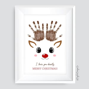Op de afbeelding: Een wit rendier met bruine handafdruk-gewei, een rode neus en zwarte ogen. De tekst "I love you deerly" en "Merry Christmas!" staat onder het rendier.