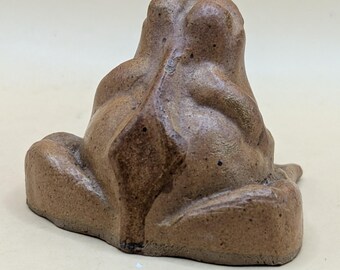 魅力的な小さな陶器のカエル。茶色の釉薬がかけられており、個性に