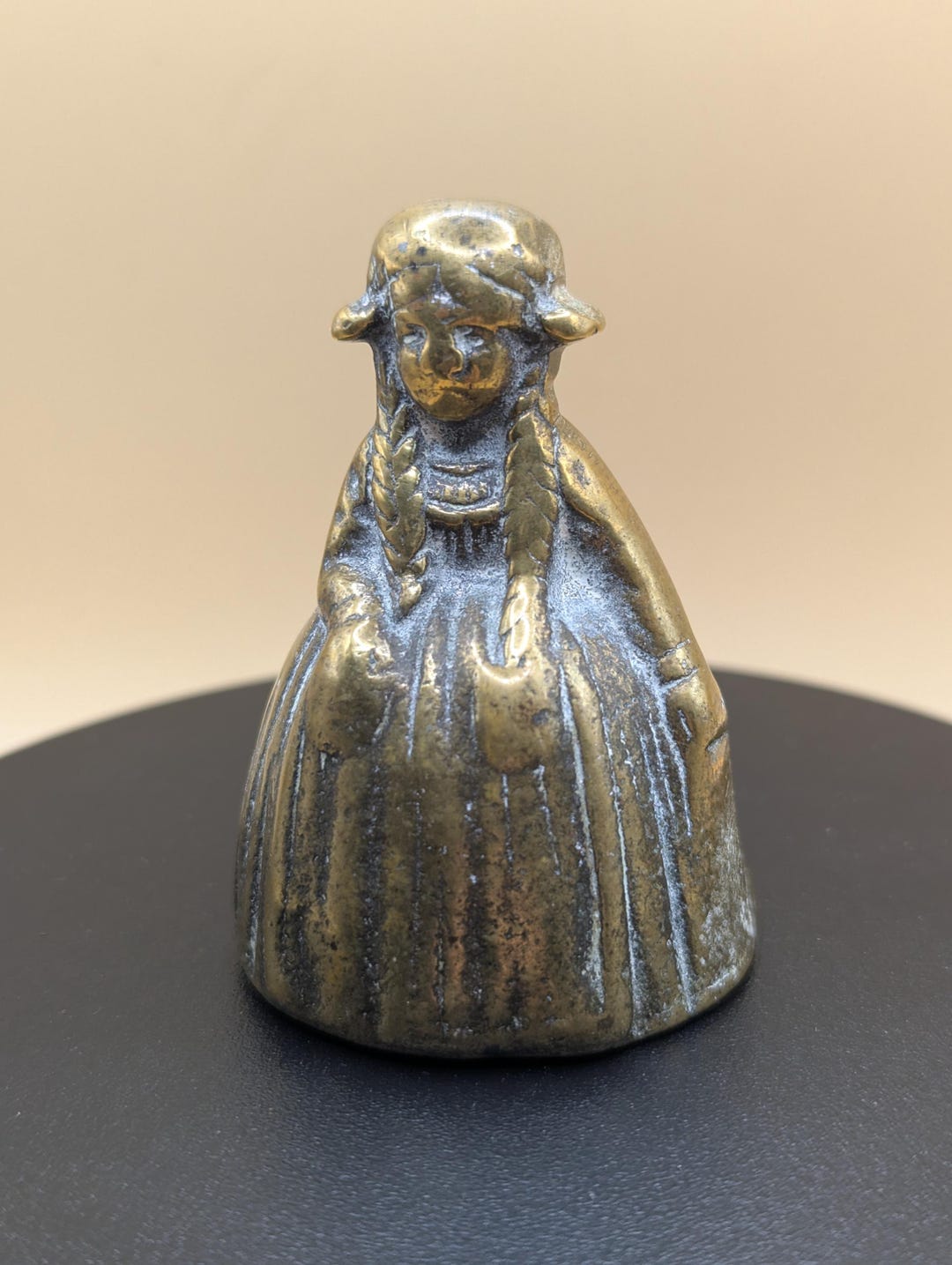 重厚な貴族階級の真鍮製小型テーブルベル。伝統的な衣装と三つ編みを