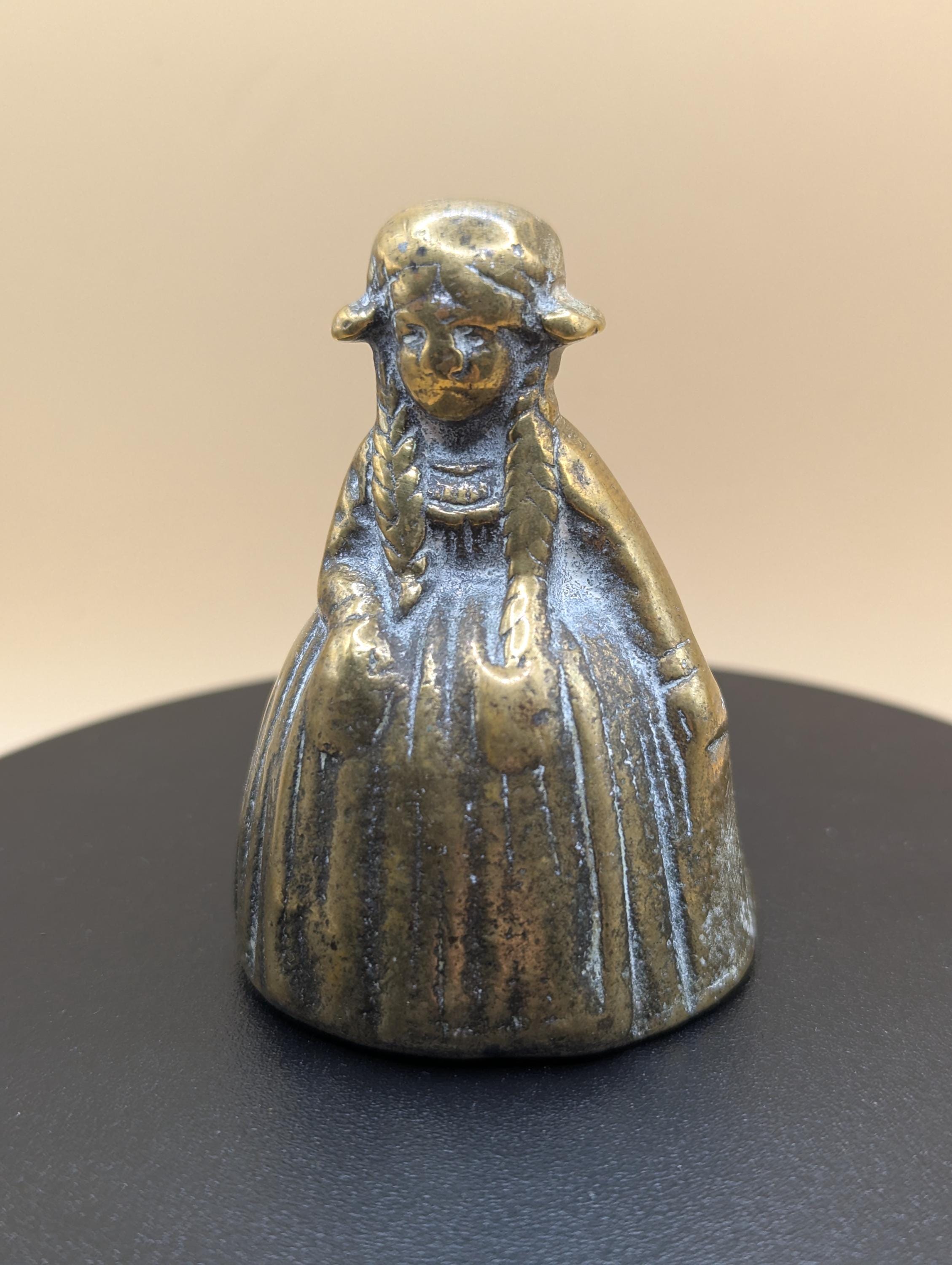 重厚な貴族階級の真鍮製小型テーブルベル。伝統的な衣装と三つ編みを