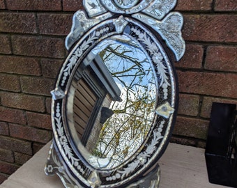 A Large and Heavy oval gypsy style dressing table/wall hanging mirror, some claimed as Venetian? I'm not sure.