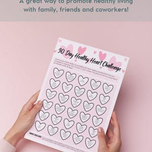 Puede incluir: Un desaf&iacute;o de 30 d&iacute;as para un coraz&oacute;n sano, impreso en rosa, con una cuadr&iacute;cula de 30 corazones. Cada coraz&oacute;n tiene una actividad diferente para completar, como "Beber 8 vasos de agua" o "Dar un paseo por la naturaleza".