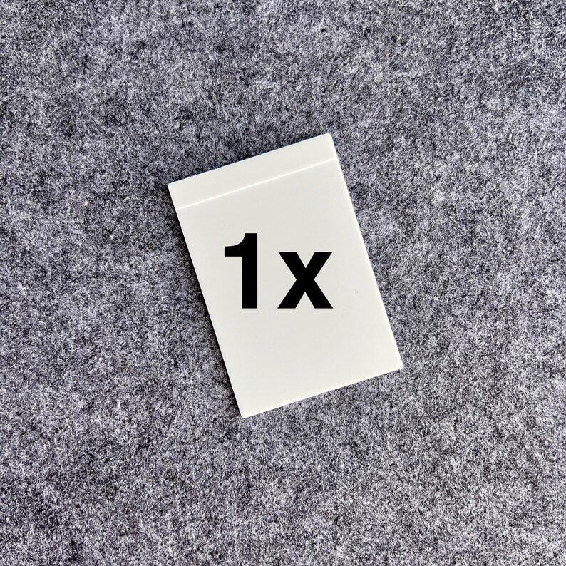 Peut inclure: Une carte rectangulaire blanche pr&eacute;sentant le texte noir en gras 1x centr&eacute; sur sa surface. La carte poss&egrave;de une finition lisse et plate avec des bords droits et nets, offrant un indicateur visuel clair et simple pour la quantit&eacute;.