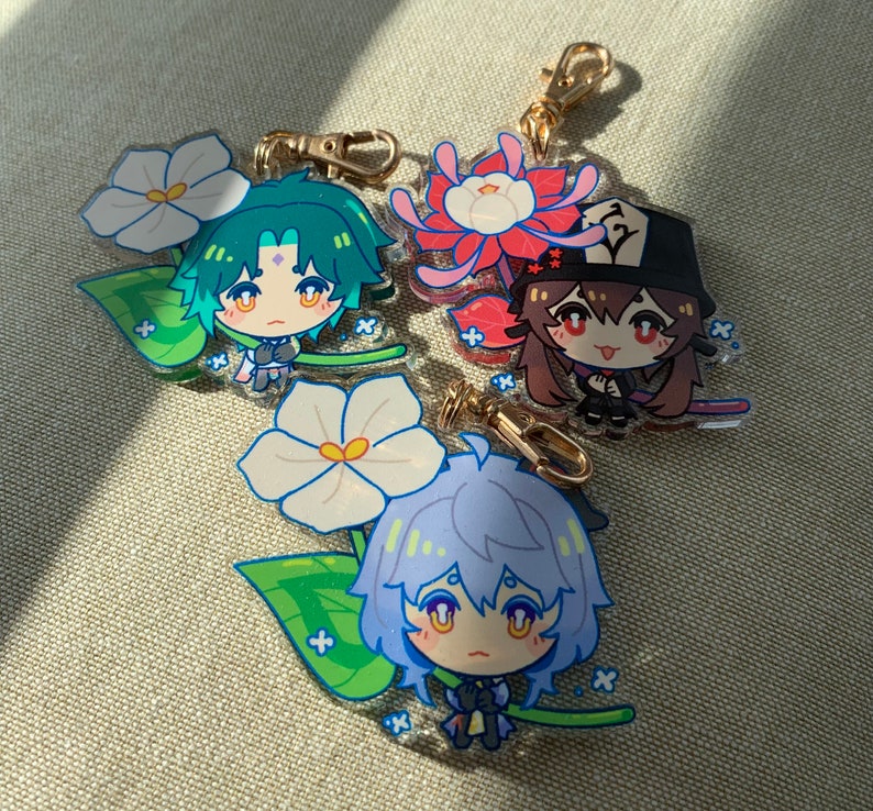 Puede incluir: Tres encantos de personajes de anime coloridos con dise&ntilde;os florales. Cada encanto presenta un personaje diferente con una expresi&oacute;n &uacute;nica y un dise&ntilde;o floral. Los encantos est&aacute;n hechos de acr&iacute;lico transparente y tienen un anillo de metal dorado para sujetar a un llavero o bolso.