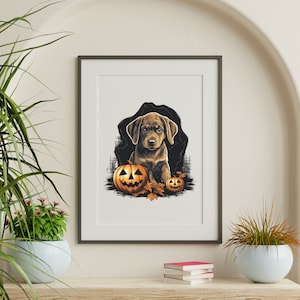 May include: A brown and white puppy dog sits in front of two orange jack-o'-lantern pumpkins with carved faces. The dog is surrounded by fall leaves. The image is in a black frame.