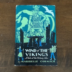 May include: A vintage book cover with a green background and a black and white illustration of a Viking warrior. The title is "Wind of the Vikings: A Tale of the Orkney Isles" by Maribelle Cormack.