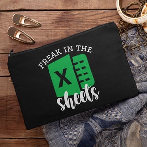 May include: Black zippered pouch with a green and white Excel logo and the text "Freak in the sheets".