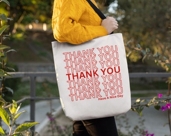 May include: White canvas tote bag with a red outline of the words "Thank You" repeated multiple times. The text "Have A Nice Day" is printed in red at the bottom of the bag.