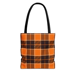 May include: Orange and black plaid tote bag with black handles.