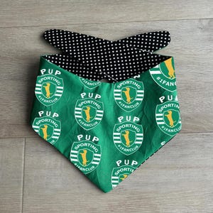 Puede incluir: Bandana reversible para perros, verde con patrón "PUP SPORTING" y silueta de perro, y negro con lunares blancos. Un accesorio para mascotas.