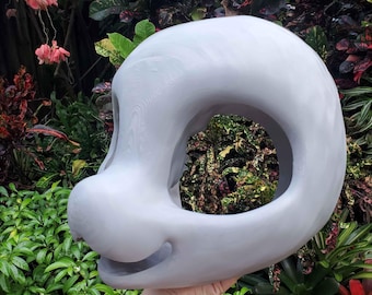 May include: A light grey, smooth, 3D-printed animal head base featuring a rounded skull shape, a prominent snout, and a wide, open eye socket area. The structure is hollow, showcasing a clean, matte finish with visible layer lines from the printing process.