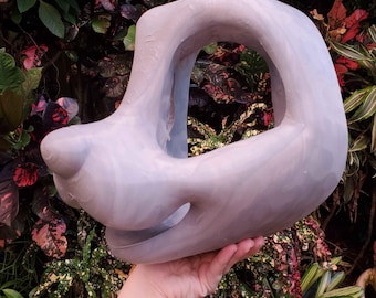 May include: A light grey, smooth, hollow animal head mask base with a prominent snout, large eye openings, and an open mouth area, crafted from a solid material with a subtle marbled texture throughout the surface of the sculpted form.