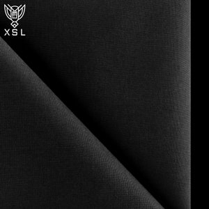 Könnte beinhalten: Schwarzer Stoff mit subtiler Textur, diagonal gefaltet im Bild. In der oberen linken Ecke befindet sich ein weißes Logo mit den Buchstaben "XSL". Der Stoff ist einfarbig, ohne sichtbare Muster oder Designs.