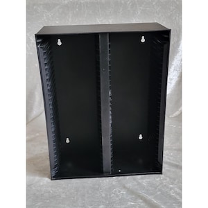 May include: A white ceramic mug with a black handle and the text "But First, Coffee" in a bold, black font. The mug is set against a blurred background, suggesting a cozy setting.