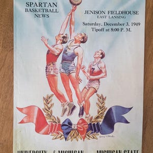 May include: Vintage basketball game program cover featuring three players reaching for a basketball. The cover includes the text "SPARTAN BASKETBALL NEWS" and "UNIVERSITY of MICHIGAN vs. MICHIGAN STATE". The game is scheduled for December 3, 1949, at Jenison Fieldhouse.