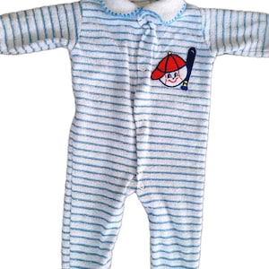 May include: A baby's one-piece footed pajama in white terry cloth with blue horizontal stripes. The collar is white with blue trim. A baseball-themed applique with a smiling baseball and bat is on the chest.