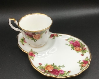 Royal Albert Bone China Old Country Roses 1962 Snack Set, sandwich/dessert plate with an attached teacup holder and includes a teacup.
