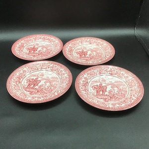 Peut inclure: Ensemble de quatre assiettes en céramique rouge et blanche avec un motif vintage représentant un chevalier à cheval. Les assiettes ont une bordure florale et une image centrale d'un chevalier chevauchant un cheval à travers un paysage.