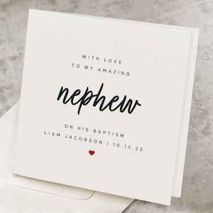 May include: A white card with black text that reads "With love to my amazing nephew on his baptism Liam Jacobson | 10.15.22" with a small red heart.