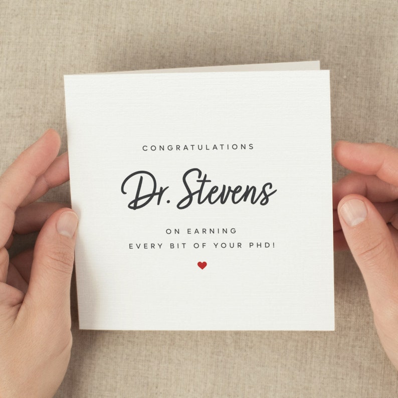 May include: Congratulations Dr. Stevens on earning every bit of your PhD! A white card with black text and a small red heart.
